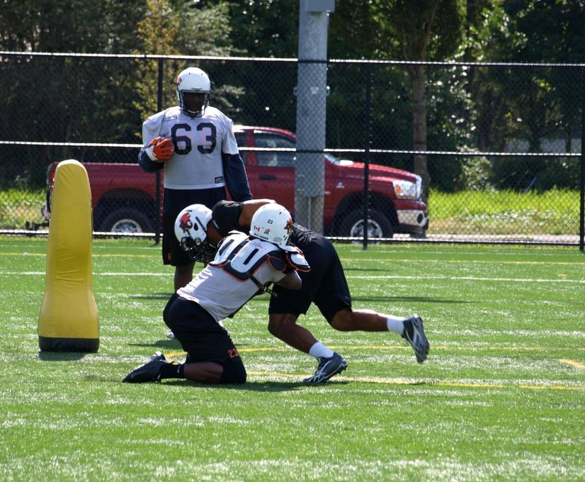 Football players tackling on the field